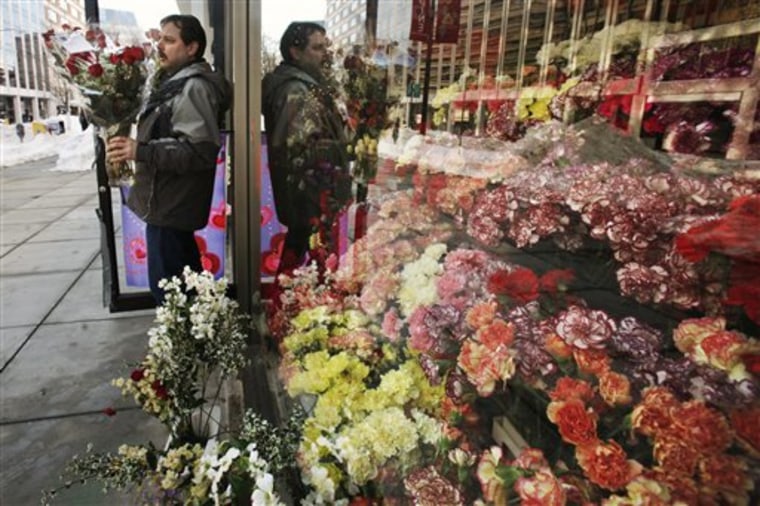 Jim Caruso takes a completed Valentine's Day bouquet to be chilled at Caruso Florist in Washington, on Thursday, Feb. 11, 2010. The shop rented four wheel drive vehicles in order to pick up employees and make deliveries in the wake of back to back snow storms. (AP Photo/Jacquelyn Martin)